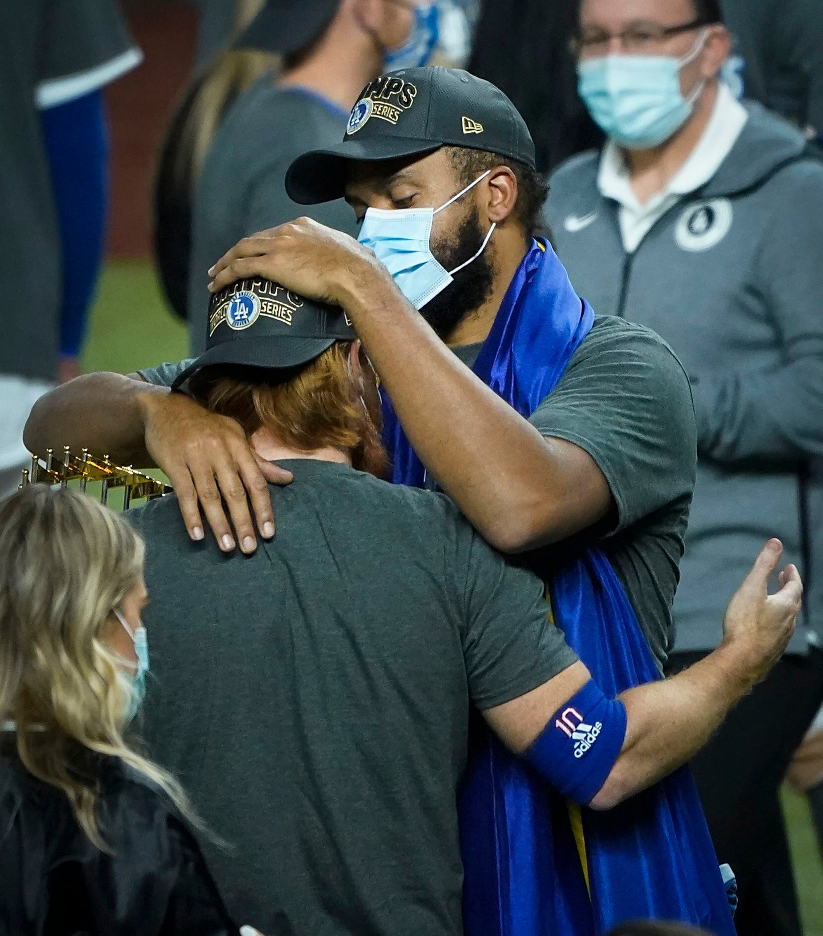 Los Angeles Dodgers relief pitcher Kenley Jansen  (facing) hugs third baseman Justin Turner...