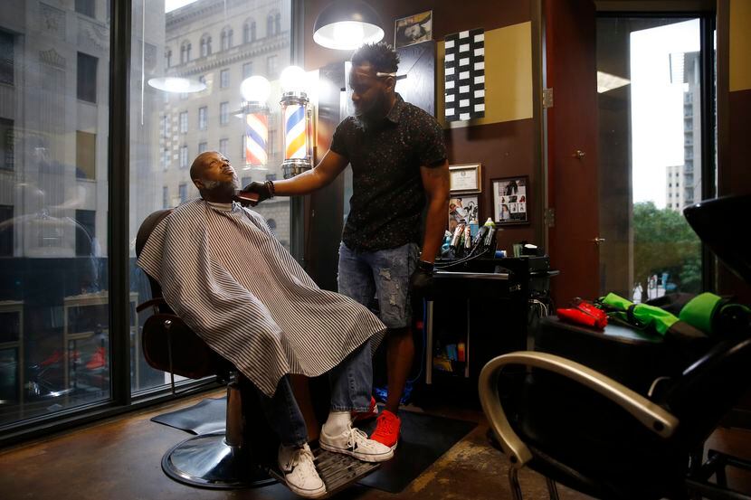 Carlos Gray, owner of Wow! "If Looks Could Kill" Hair Studio in downtown Dallas, works on...