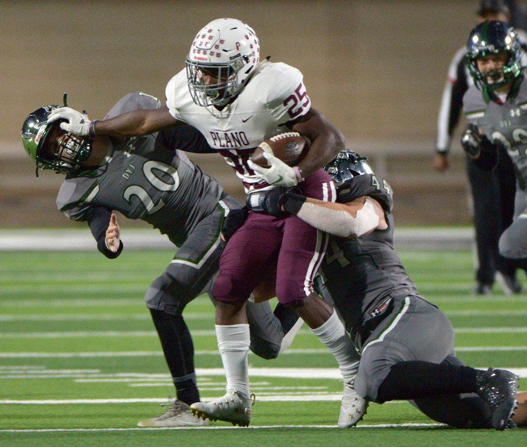 Plano's Tylan Hines tries to run through the tackle attempts by Prosper's Will Schreve (20)...