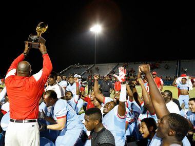 Skyline's head coach, Reginald Samples, holds the trophy up after beating Spring Westfield,...