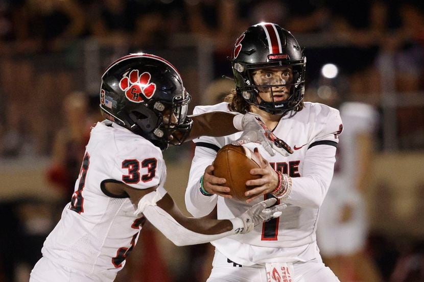 Colleyville Heritage quarterback Luke Ullrich (1) hands off to Colin Bennett (33) during a...