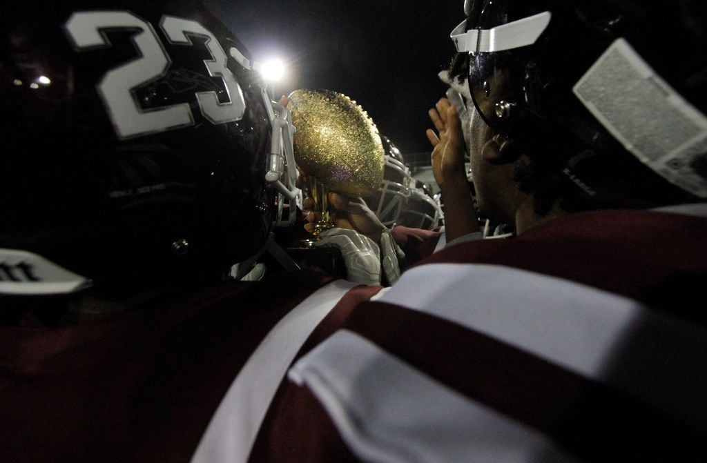 Members of the Red Oak Hawks celebrate at midfield after receiving the District 6-5A...