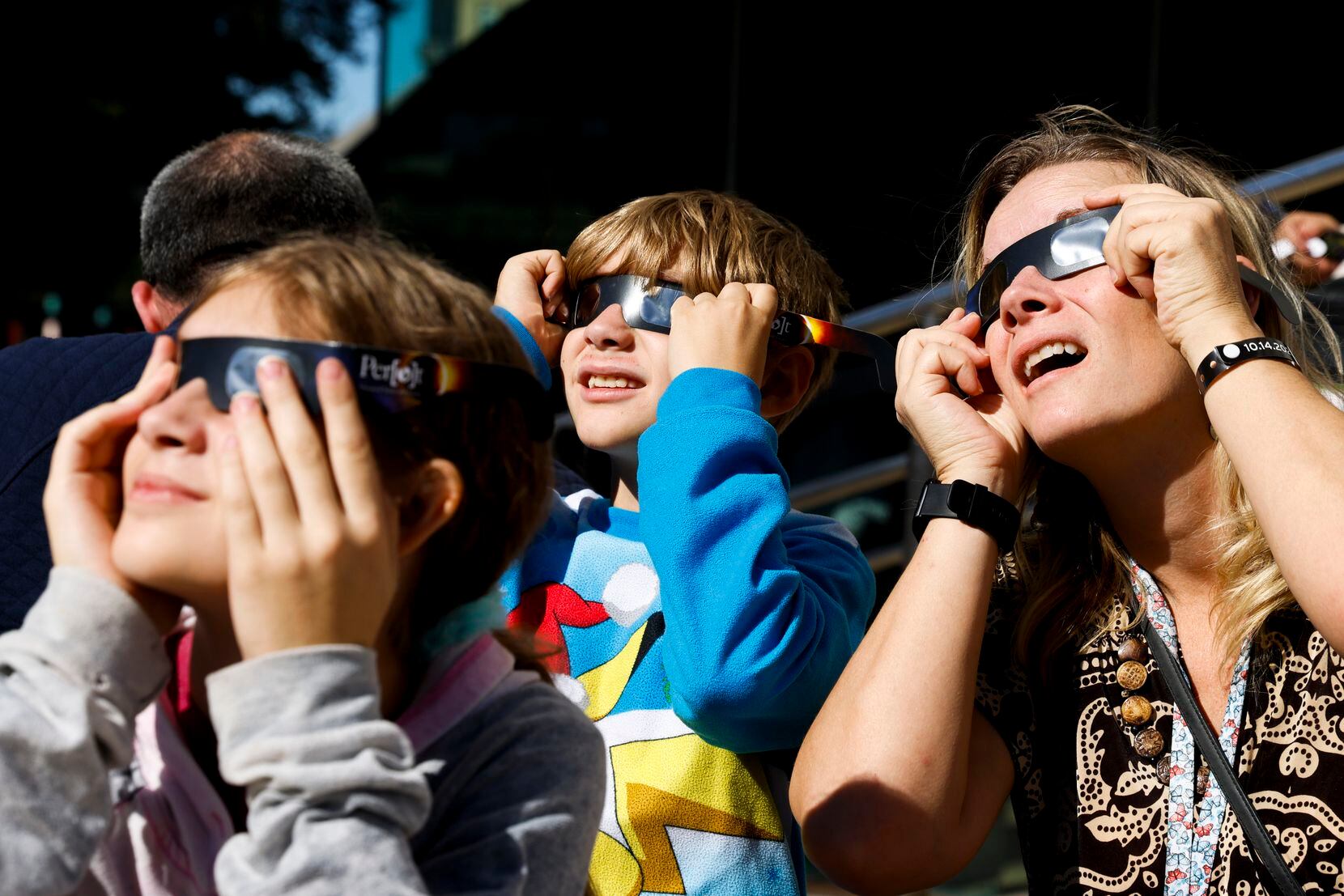 From left, Elizabeth Butler, 11, her brother Bryan, 10, and mother Marie take a peek of the...