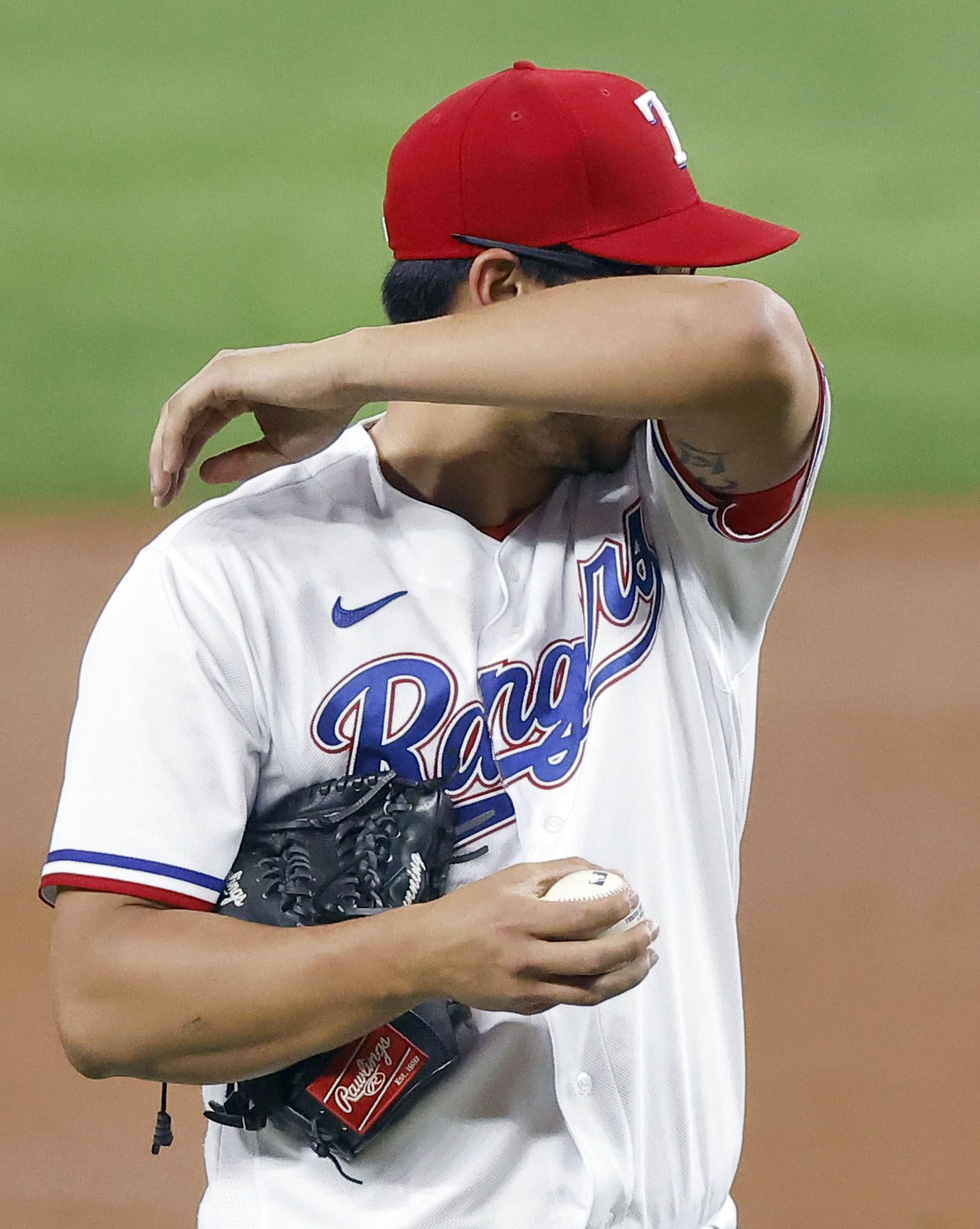 Texas Rangers starting pitcher Dane Dunning (33) wipes his brow after getting off to a rough start in the second inning against the Los Angeles Angels at Globe Life Field in Arlington, Texas, Wednesday, April  28, 2021. (Tom Fox/The Dallas Morning News)