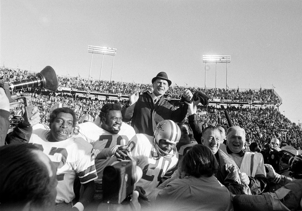 Dallas Cowboys coach Tom Landry is carried off the field on the shoulders of his players...