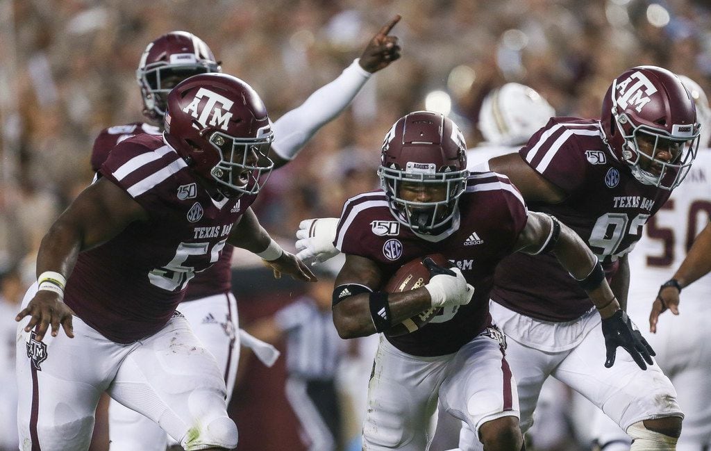 Texas A&M Aggies defensive back Leon O'Neal Jr. (9), middle, celebrates with defensive lineman Justin Madubuike (52), left, and defensive lineman Jayden Peevy (92), right after making a play during the first quarter of a college football game between Texas A&M and Texas State on Thursday, Aug. 29, 2019 at Kyle Field in College Station, Texas.