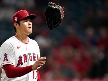 Los Angeles Angels starting pitcher Shohei Ohtani (17) tosses his glove as he returns to the dugout in the middle of the fourth inning of a baseball game against the Texas Rangers Friday, Sep. 3, 2021, in Anaheim, Calif. (AP Photo/Ashley Landis)