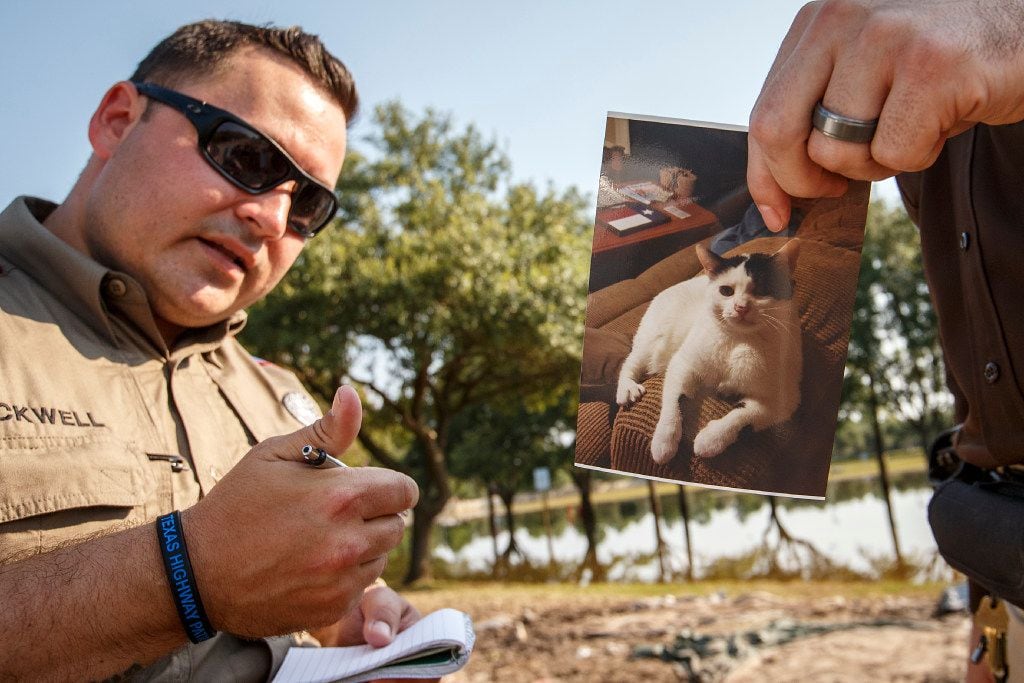 Texas DPS Trooper Mike Blackwell takes notes on a resident's pet and address before going...