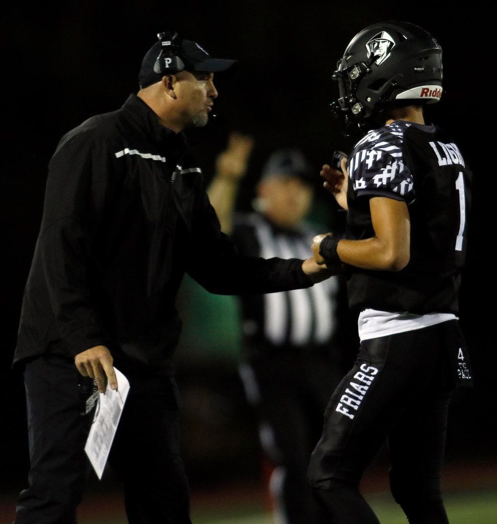 Bishop Lynch head coach Greg Price speaks with Friars quarterback Michael Light (1) during a...