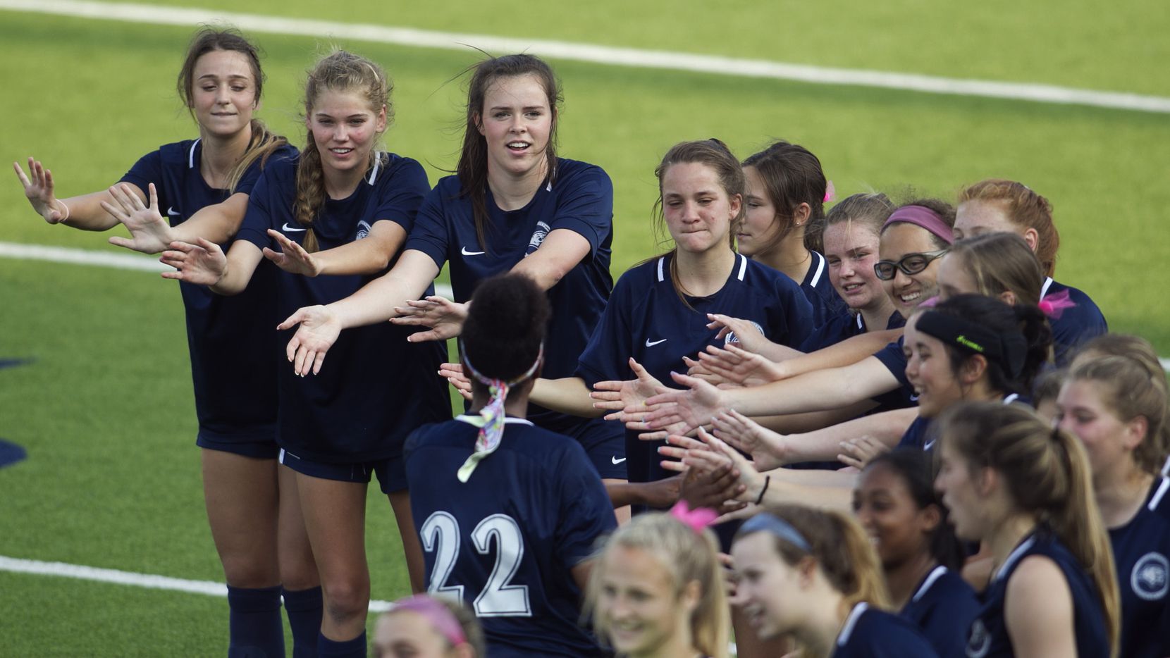 Flower Mound players form a curved reception line to welcome teammate Lexie Ryan (22) to the...