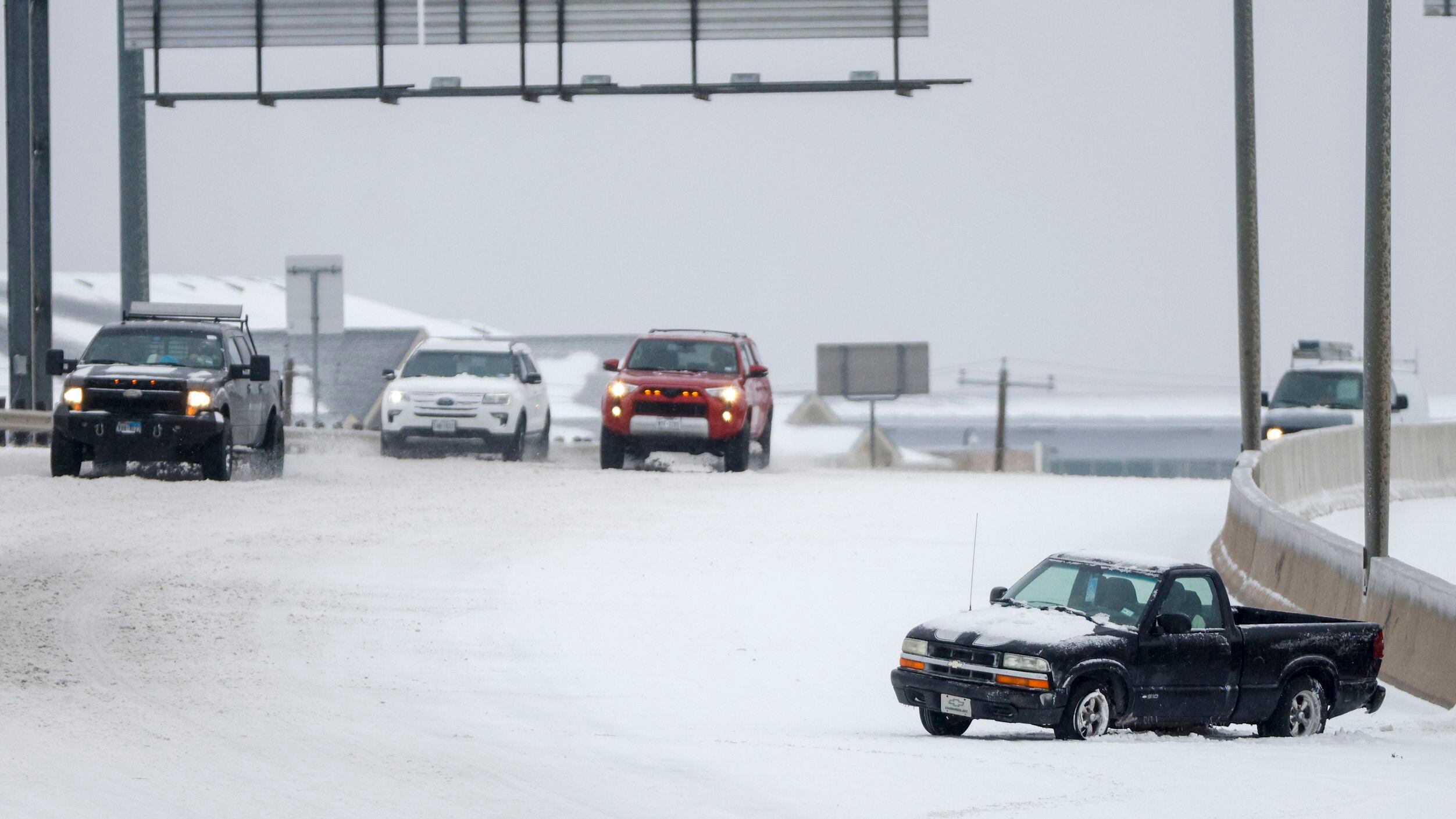 A disabled car sits after crashing along a snow and ice covered westbound Interstate 20 near...