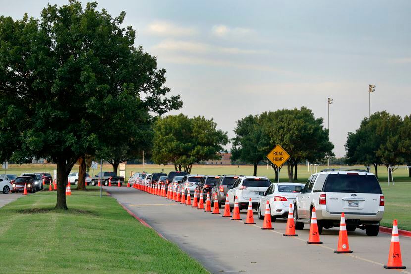 A line of drivers wait to have a nasal swab test in a drive-through COVID-19 testing site at...
