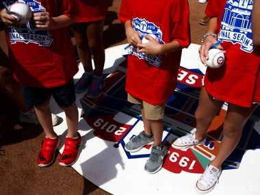 Young Rangers fans wait with their baseballs to be signed before a MLB game between Texas...