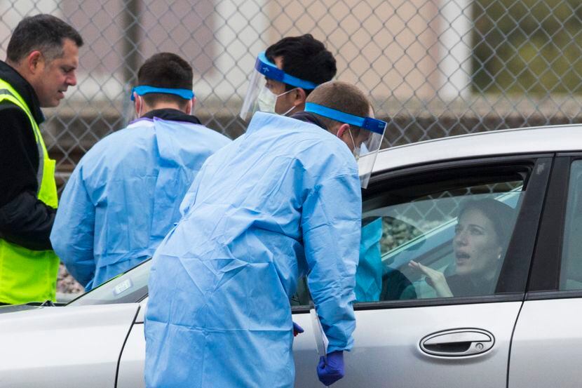 A motorists talks with staff at the drive-through coronavirus testing site at American...