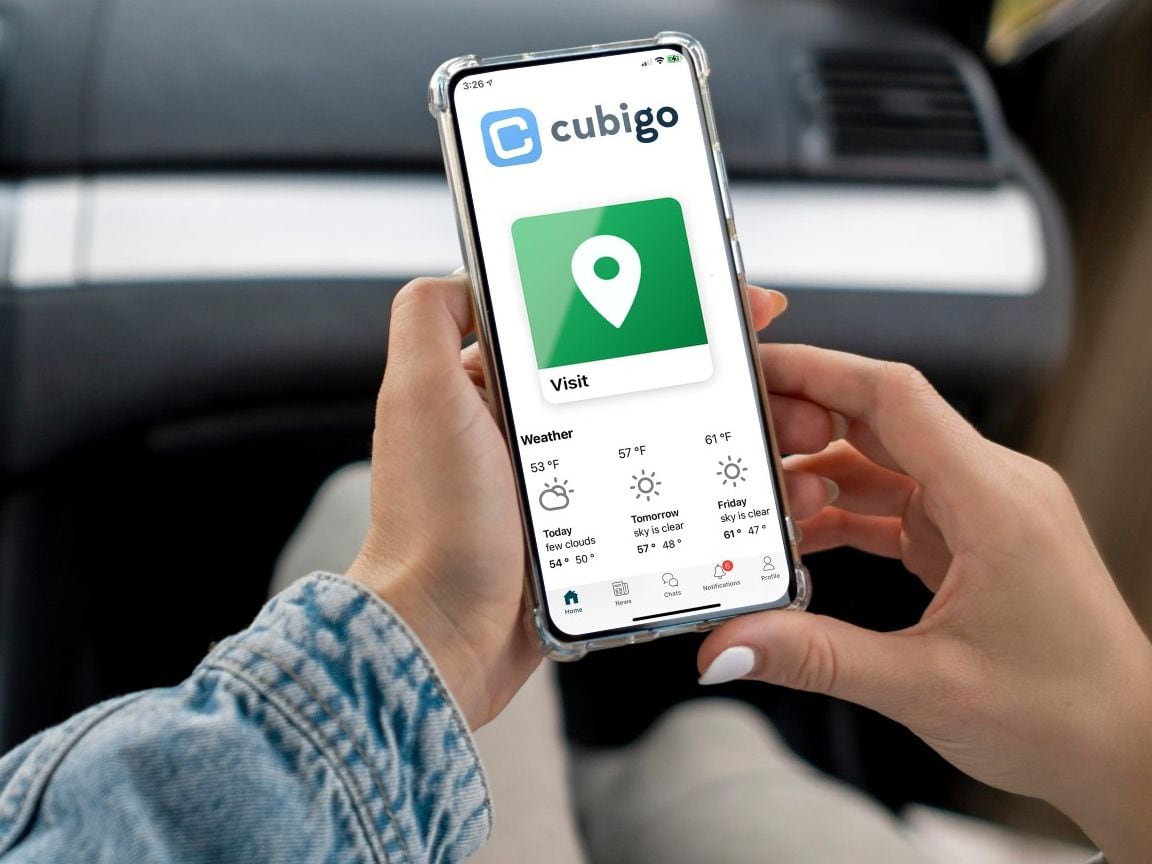 Person looking at Cubigo platform on their cell phone while sitting in a car.