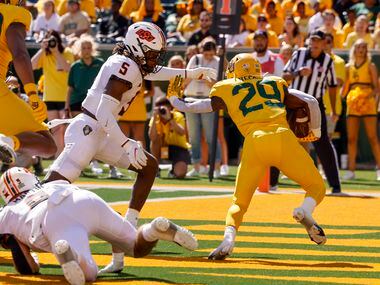 Oklahoma State safety Kendal Daniels (5) tackles Baylor running back Richard Reese (29) in...