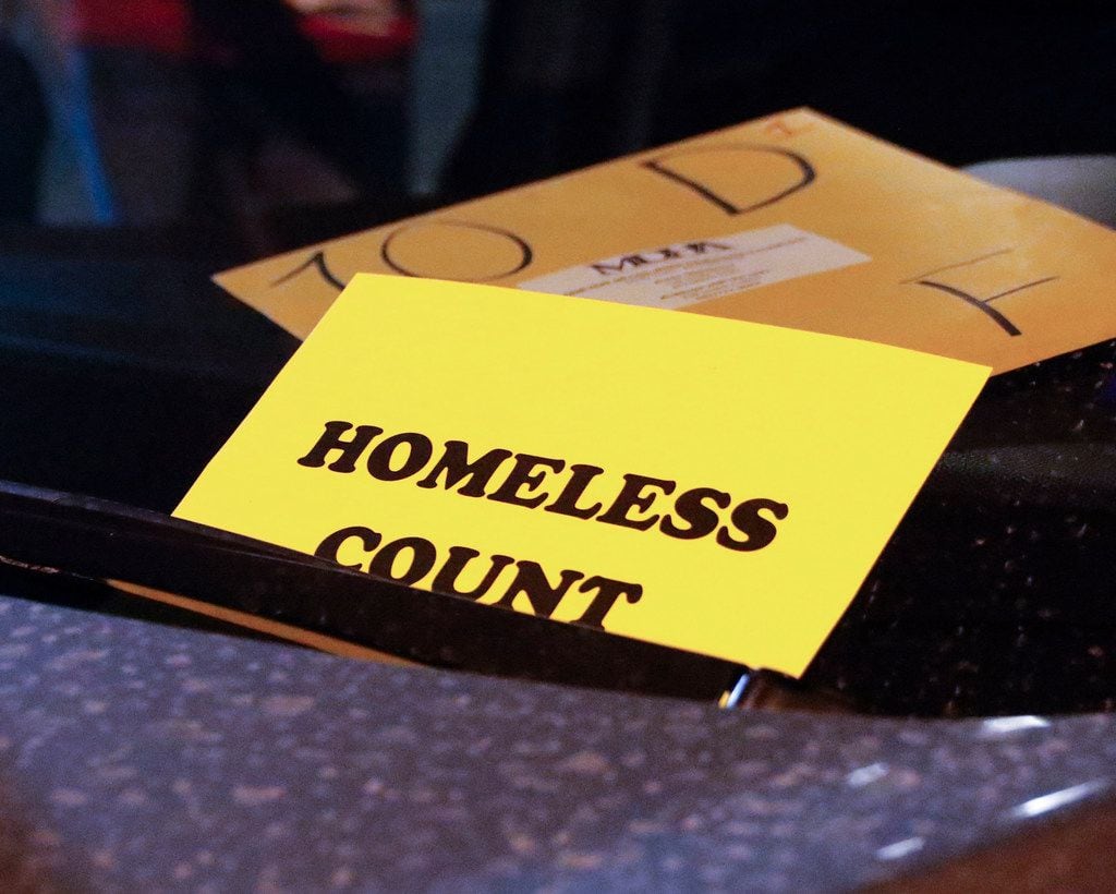 Dennis Friedel, a volunteer with the Metro Dallas Homeless Alliance, placed a "homeless...