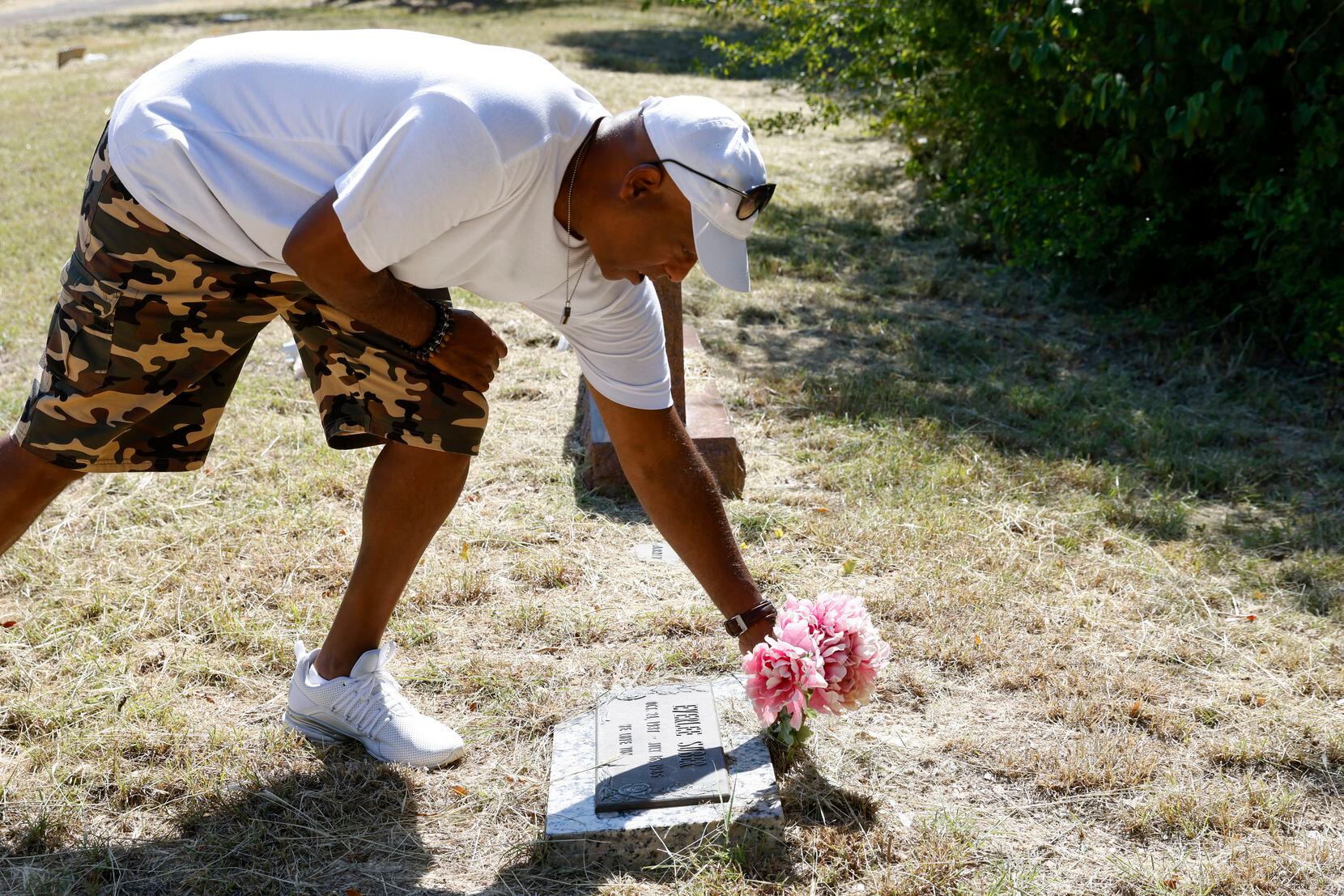 Antonia Suber removed the faded flowers on the cemetery marker of his mother, Everlee Suber,...