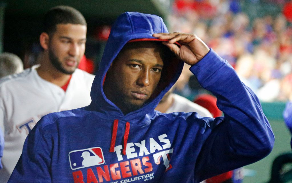 Texas Rangers third baseman Jurickson Profar (19) dons a sweatshirt as the temperature drops...