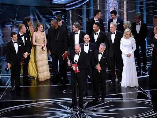 Jordan Horowitz, frente al centro, y el elenco de “La La Land” reciben por error el premio a...