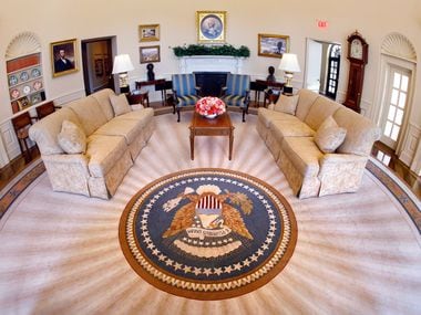A circular rug bearing the Presidential Seal covers the wood floor in the Oval Office...