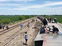 In this photo provided by Dax McDonald, an Amtrak passenger train lies on its side after...