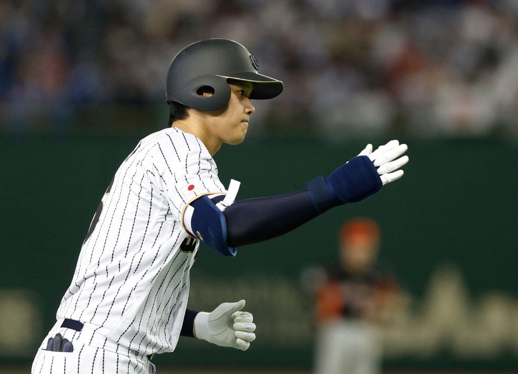 Japan's designated hitter Shohei Otani rounds bases after hitting a solo home run off...