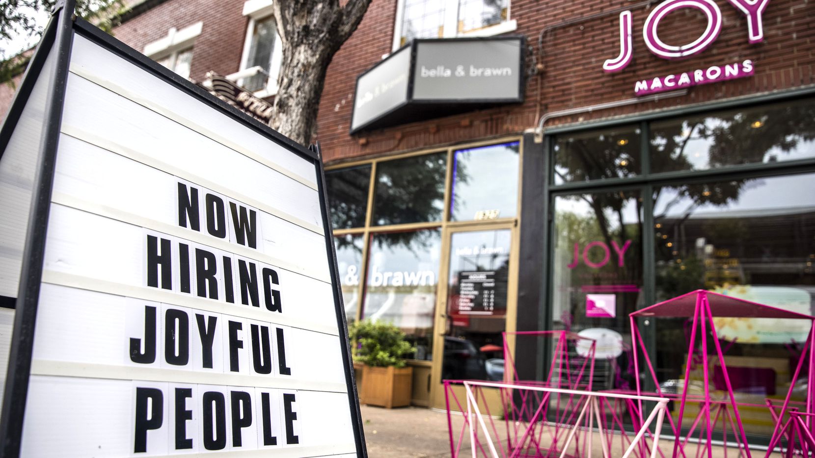A “Now Hiring” sign stood outside JOY Macarons in Dallas earlier this summer.