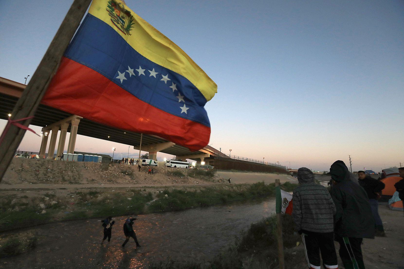 A Venezuelan flag waved as migrants try to cross the Rio Grande from Ciudad Juárez, Mexico...
