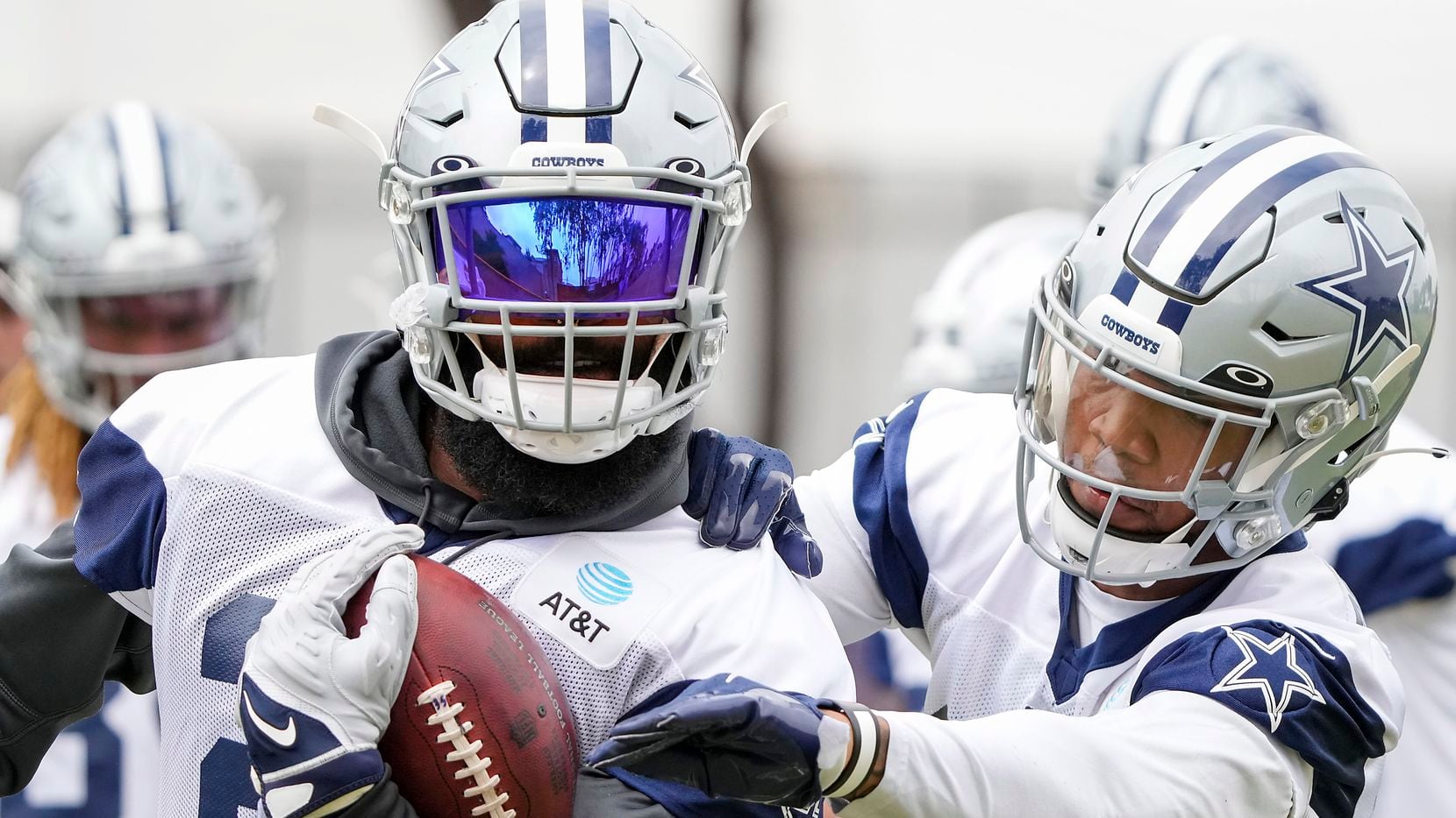 Dallas Cowboys running back Ezekiel Elliott (21) works against  running back Tony Pollard (20) in a fumble drill during a practice at training camp on Tuesday, July 27, 2021, in Oxnard, Calif. 
