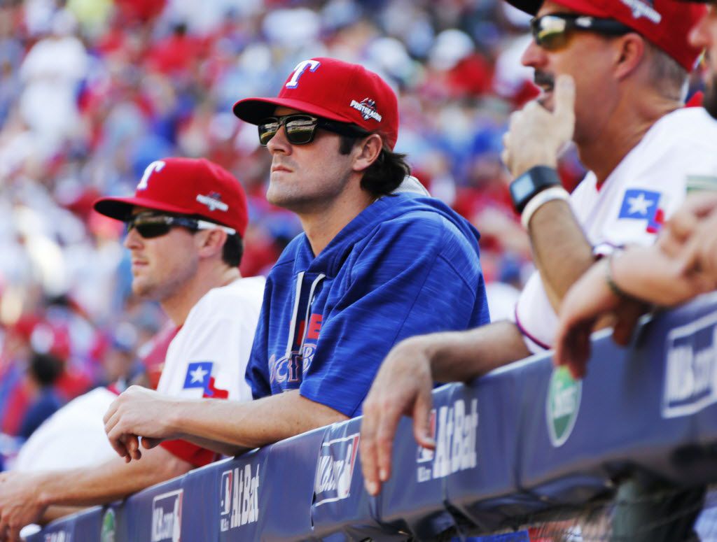 Texas Game 5 starting pitcher Cole Hamels, center, watches the action from the dugout during...