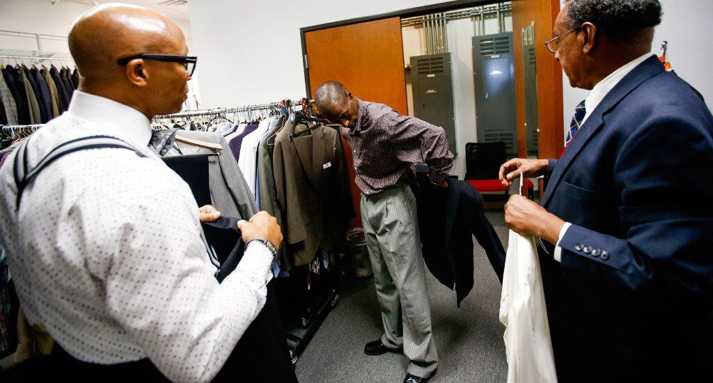 Workforce Solution employees guide Joshua Miller during his suit fitting at the Southwest...