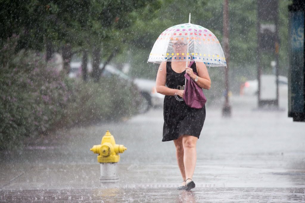 A woman made her way through a downpour Friday in downtown Dallas.