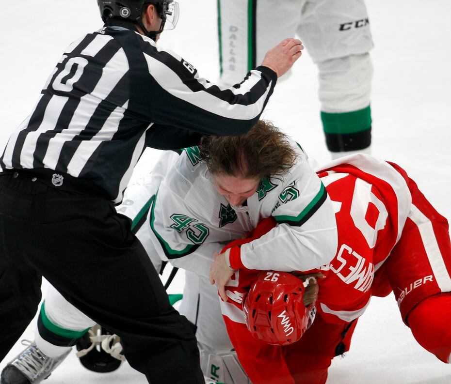 A game official moves in to calm a scrum which broke out between Dallas Stars' Sami Vatanen...