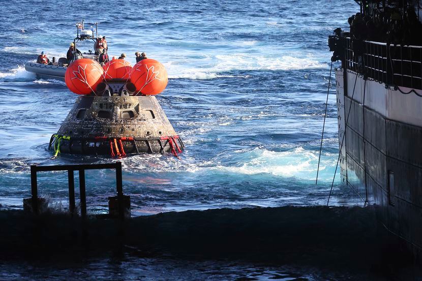 La cápsula Orion de la NASA es llevada a la cubierta del USS Portland después del regreso...
