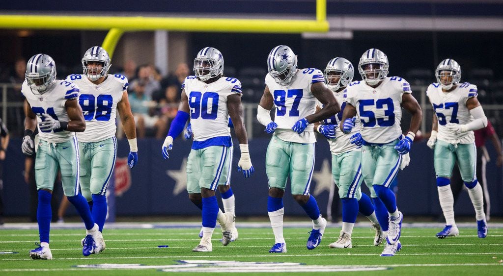 Dallas Cowboys players walk to the sideline after a turnover during the first quarter of an...