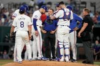 Texas Rangers' Josh Smith (8), Jonah Heim (28), umpire Jim Wolf, right, and others look on...