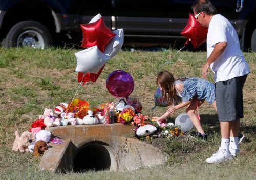 Miley Grahmann, de 8 años, deja un osito de peluche en el sitio donde fue hallado el cuerpo...