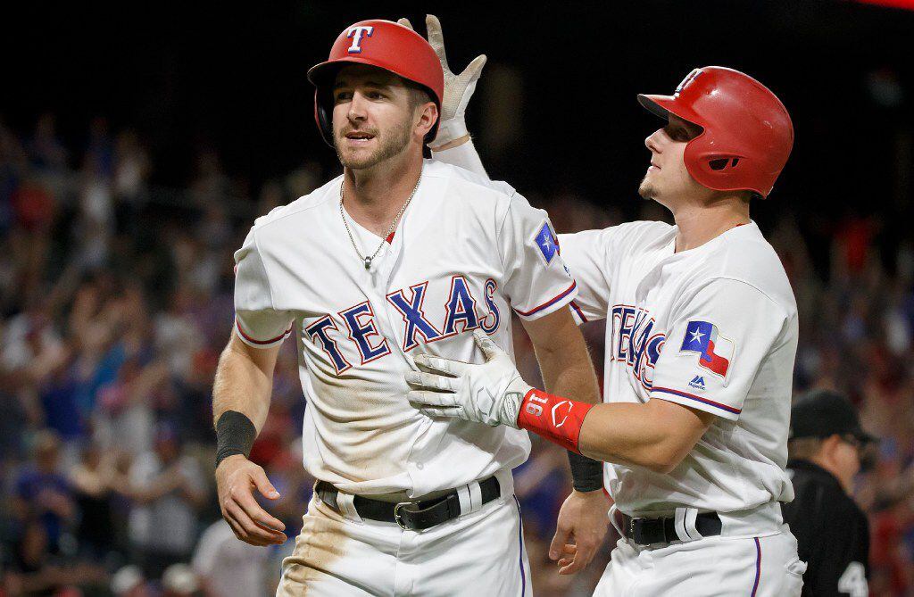 Texas Rangers outfielder Jared Hoying celebrates with outfielder Ryan Rua after scoring...