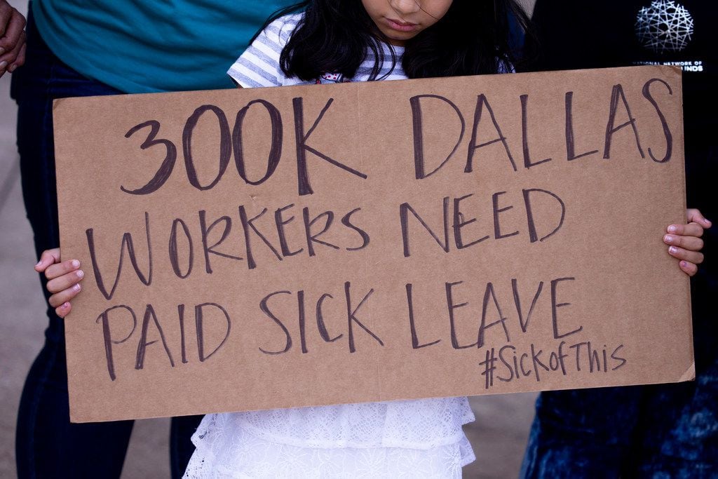A  girl held a sign during during a news conference about a paid sick time ordinance outside of the Dallas City Hall on June 20, 2019.