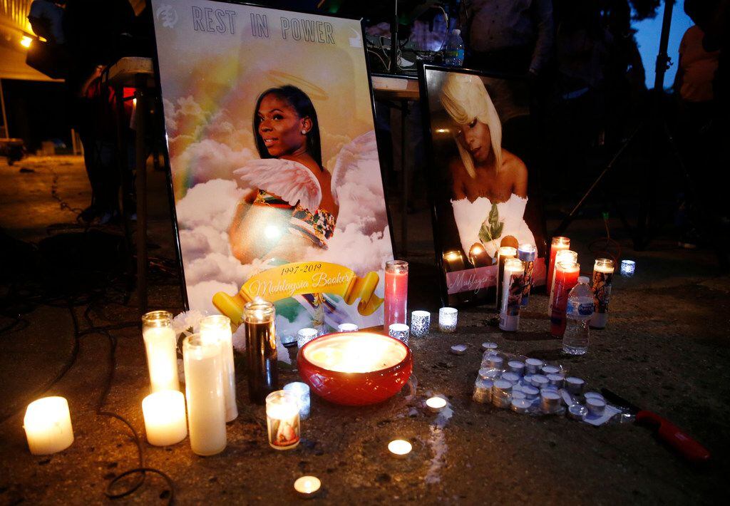 Candles illuminate images of Muhlaysia Booker during a  vigil for her in Dallas on May 22,...