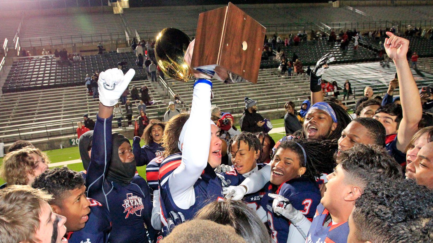Denton Ryan K Clayton Roblyer (83) holds the game trophy high, after the Ryan coach presented it to him at the end of Ryan’s 37-33 win over Longview in the Class 5A Division I Region II semifinal football playoff game at Mesquite Memorial Stadium in Mesquite on Friday, November 26, 2021. (John F. Rhodes / Special Contributor) 