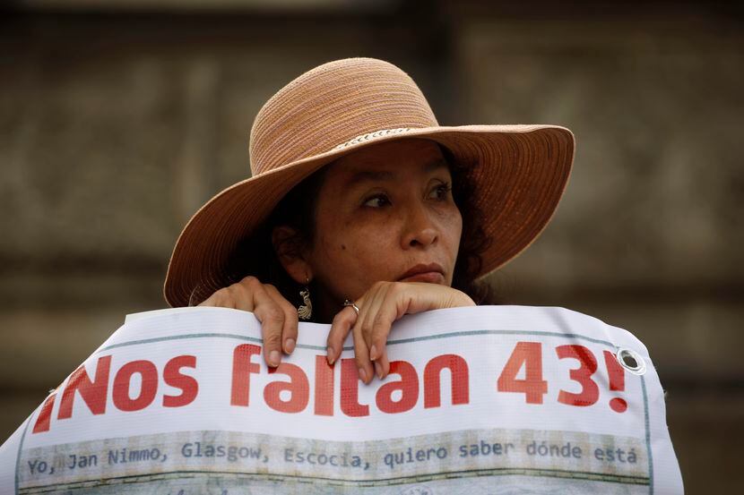 Una mujer lleva una pancarta que dice en español "¡Nos faltan 43!", en referencia a los 43...