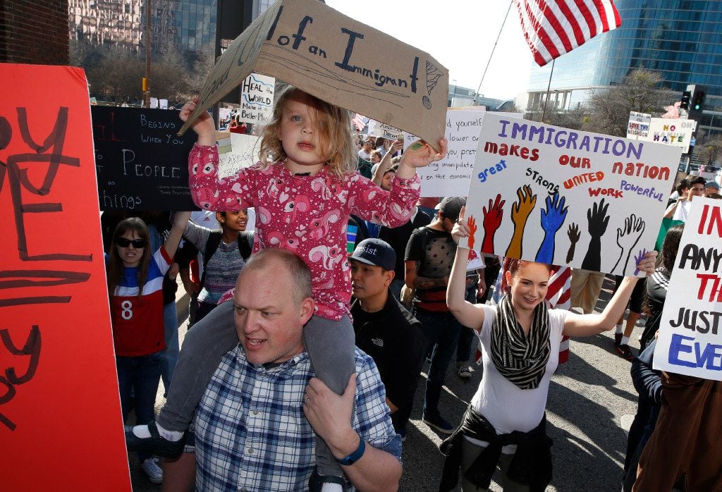 Tjepke Heeringa holds his daughter Lulu Heeringa, 4, during a protest for immigrant and...