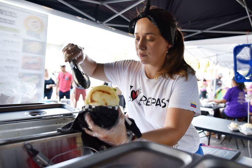 Pamela Lozano, 34, places ingredients inside of an arepa at her food booth Arepa Nation at...