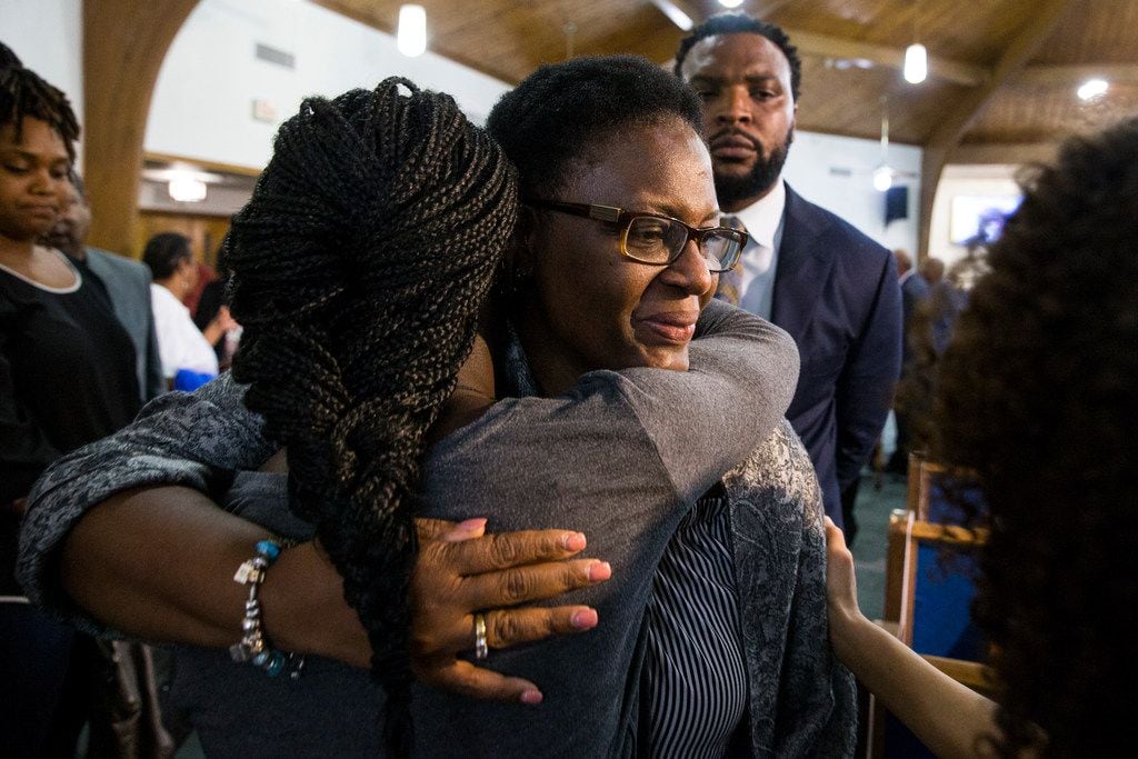 Allison Jean embraces her son's friends following a prayer vigil for Botham Shem Jean at the...