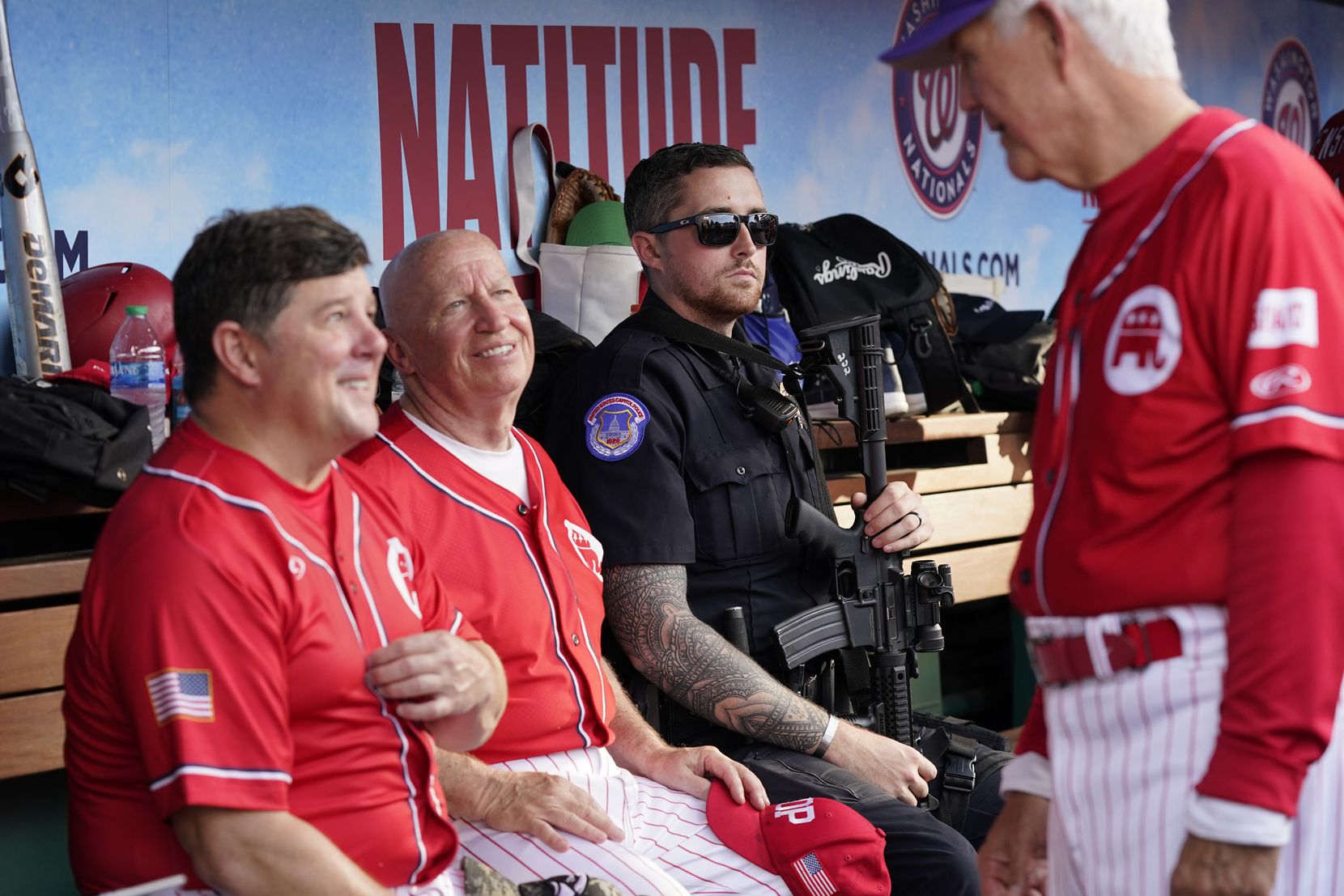 A member of the U.S. Capitol Police sits in the dugout alongside Rep. Steven Palazzo,...
