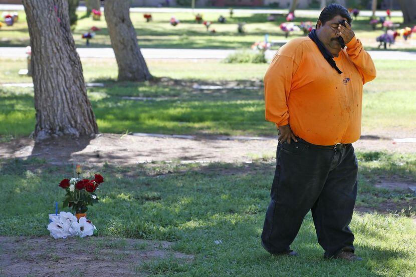Margarito Castro llora frente a la tumba de su hijo Manuel "Manny" Castro García, de 19...