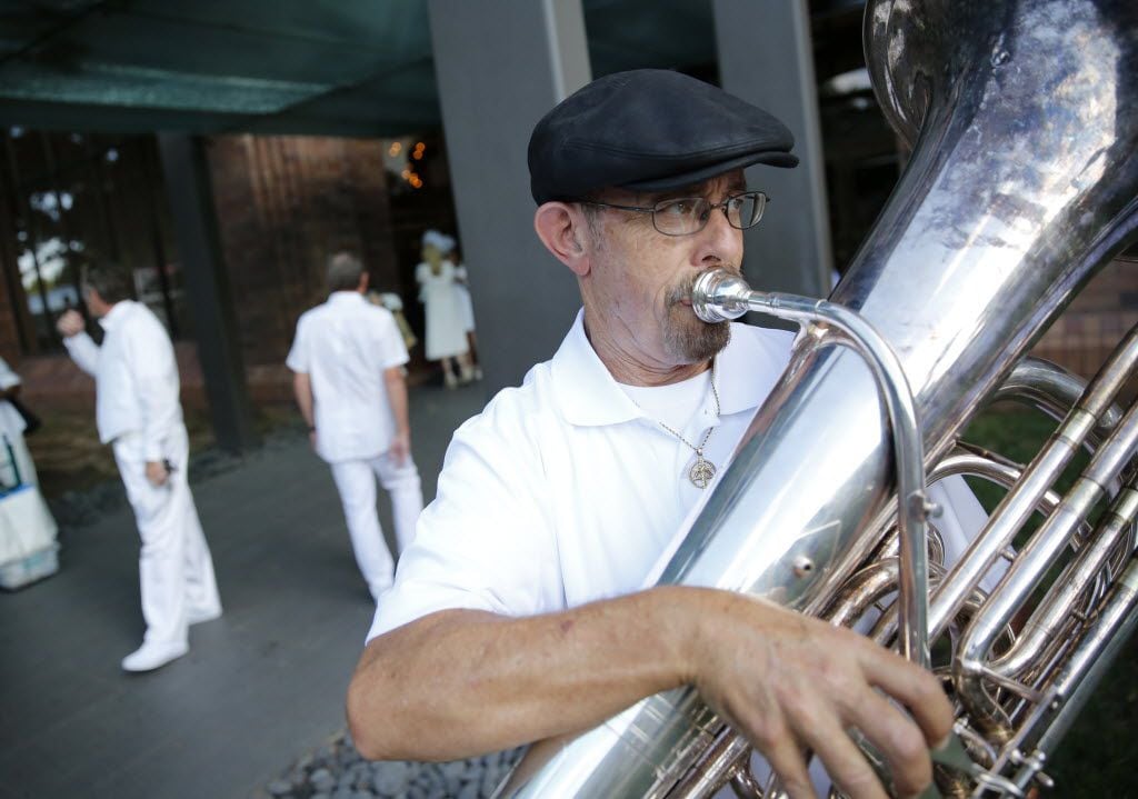 Eugene LeBeaux, a member of the Razzmajazz band, plays the tuba outside the Hilton Anatole,...