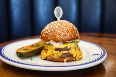 Hudson House's double meat, double cheese burger is topped with pickles, minced onion and...